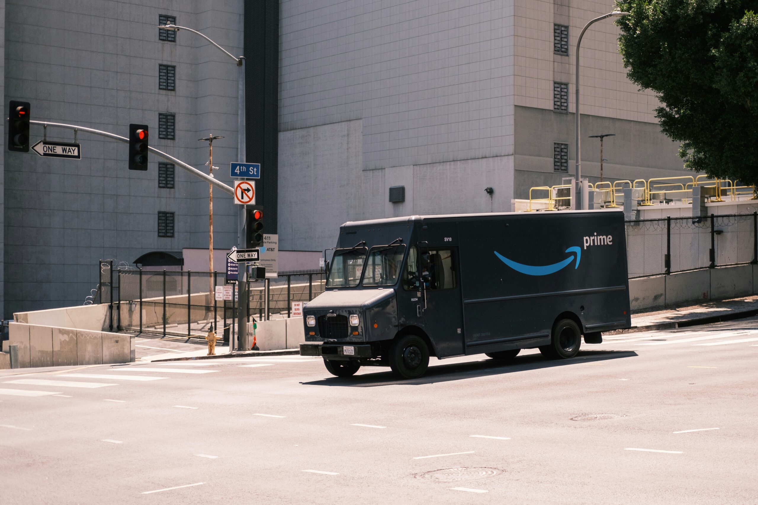 Amazon delivery driver carrying a defibrillator from a branded van to assist a medical emergency.